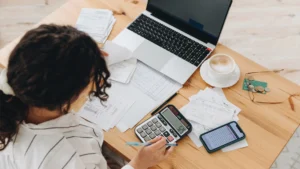 Woman writing and calculating hidden homeownership expenses